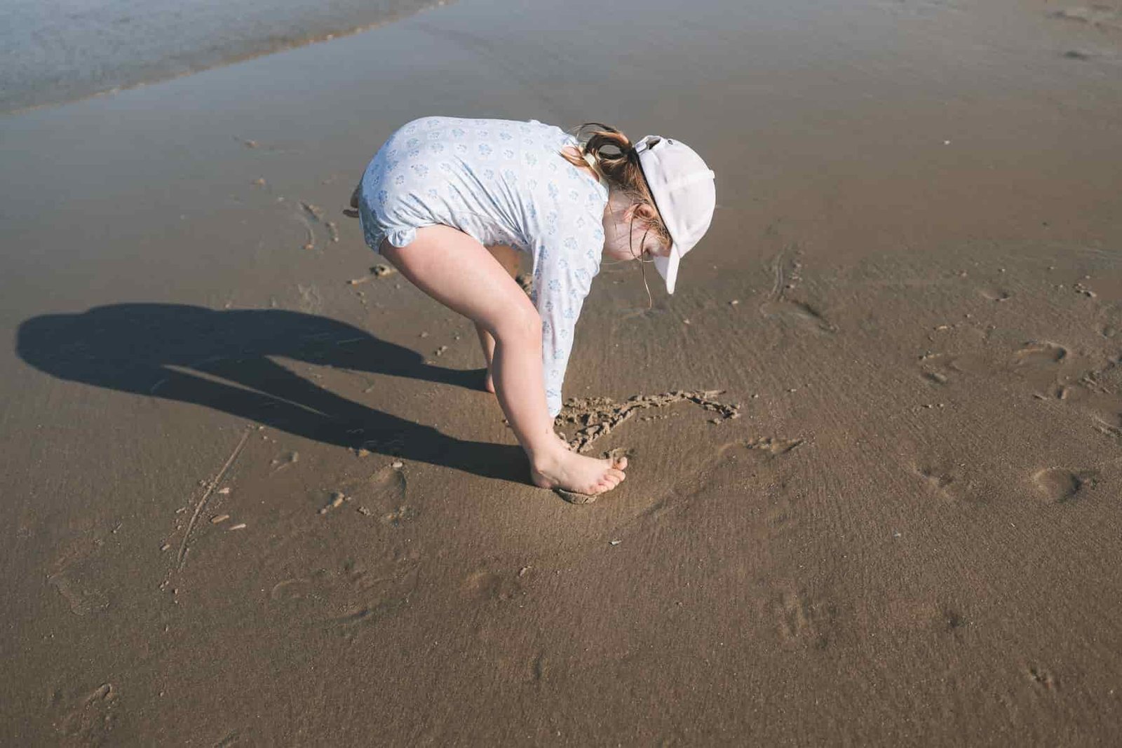 Toddler writing on the sand Toddler writing on sand
